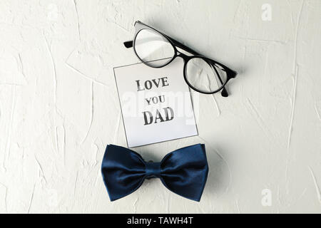 Inscription aime papa, noeud papillon bleu et lunettes sur fond blanc, de l'espace pour le texte et Vue de dessus Banque D'Images