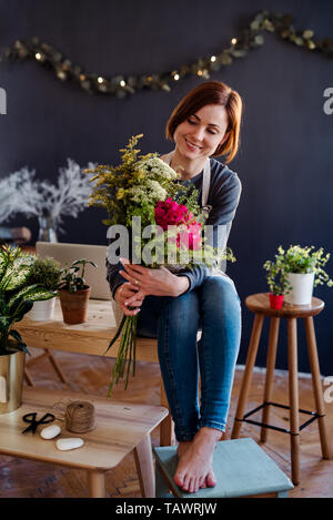 Jeune femme créative dans un magasin de fleur. Un démarrage de fleuriste entreprise. Banque D'Images