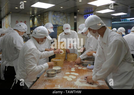 Le personnel de cuisine portant des masques hygiéniques prépare derrière la vitre xiaolongbao un type de petit pain chinois cuit à la vapeur (baozi) traditionnellement préparé dans un xiaolong, un petit panier vapeur en bambou au restaurant taïwanais DIN Tai Fung à Taipei Taiwan Banque D'Images