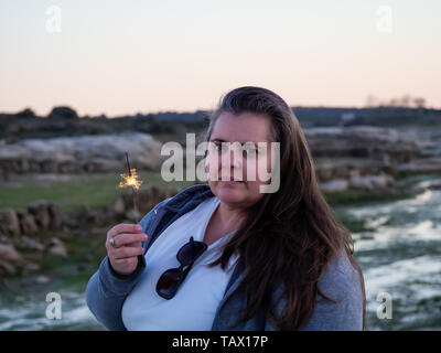 Un adulte avec une femme curvy flare grésillait dans sa main Banque D'Images