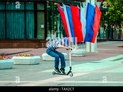 05 14 2019 La Russie, de l'oblast de Briansk. Adolescent voler dans un saut sur un scooter à la place de la ville. Banque D'Images