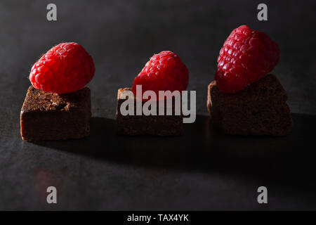 Brownies au chocolat avec garniture framboise. L'éclairage à faible clés Banque D'Images