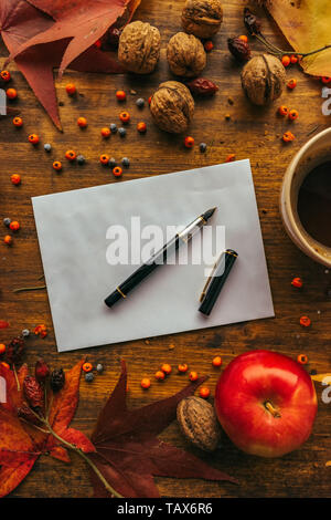 Enveloppe poste automne maquette mise à plat sur une table en bois décoré avec des feuilles d'érable sec et de fruits de saison Banque D'Images