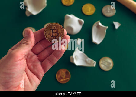 En tenant la main de Bitcoin broken Piggy Bank, pièce cryptocurrency concept d'épargne. Banque D'Images