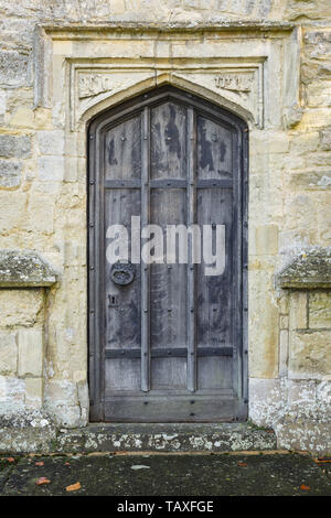 L'ancienne porte en bois cintrées en entrée d'une vieille église en pierre médiévale en Angleterre Banque D'Images