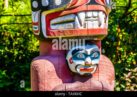 Détails d'un article de la couleur de la Thunderbird House 'Poster' Totem représentant le visage d'un Grizzli. Le pôle est situé dans le Parc Stanley Banque D'Images