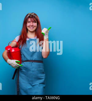 Image de femme heureuse avec fleuriste arrosoir en mains de doigt à l'autre Banque D'Images