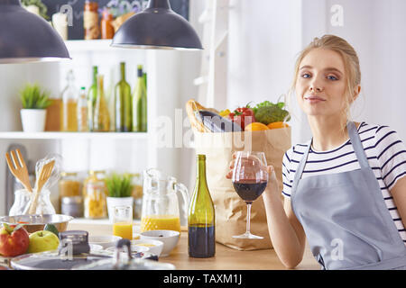 Jeune femme avec vin rose à table avec des fruits, peu de profondeur Banque D'Images