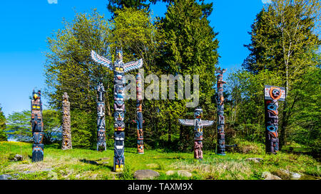 Les Totems colorés représentant des symboles religieux et d'art de la côte ouest les peuples autochtones placés dans le parc Stanley à Vancouver, BC, Canada Banque D'Images