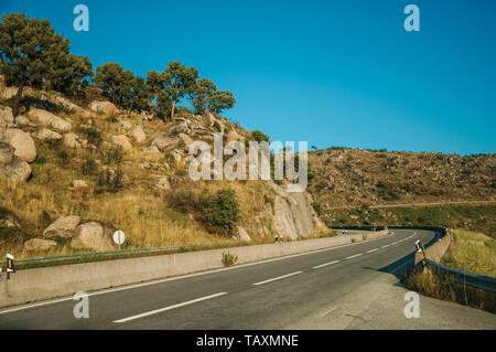 En passant sur un paysage vallonné avec des pierres sur le coucher du soleil à les hauts plateaux de la Serra da Estrela. La plus haute chaîne de montagne au Portugal continental. Banque D'Images
