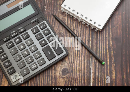 Calculatrice sur fond de bois avec le bloc-notes et crayon, le concept d'économie d'entreprise et finances publiques Banque D'Images