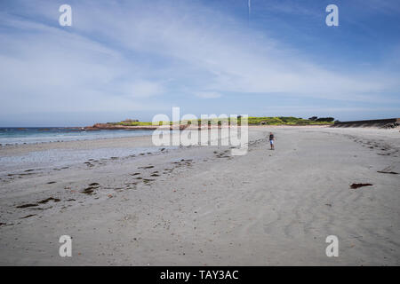 Homme debout sur la magnifique plage de sable blanc dans la baie de Vazon - Guernsey, Channel Islands (UK) Banque D'Images