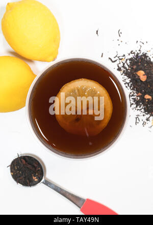 Tasse de thé citron top vertical avec vue sur la tranche de citron et feuilles de thé et de fruits en arrière-plan Banque D'Images