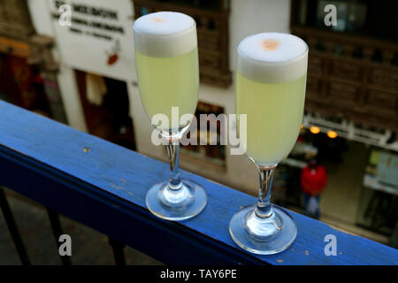 Deux verres de Pisco Sour péruvien avec le bâtiment historique de la vieille ville historique de Cusco, Pérou, Amérique du Sud Banque D'Images