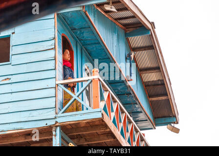 Nakaraj Nakhon, Laos - Dec 2016 : femme debout fièrement et à la recherche sur le balcon de maison flottante sur le bateau sur le fleuve Mekong Banque D'Images