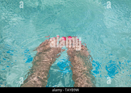 Mesdames pieds sous l'eau dans la piscine .Image Banque D'Images