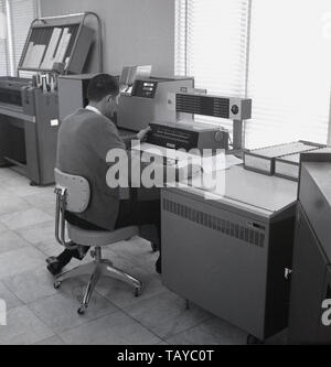 Au milieu des années 1960, historique, un homme travaillant à la console d'un système de calcul IBM 1130, avec d'autres équipements périphériques dans la chambre. Introduit en 1965, le 1130 était destinée à l'éducation et les marchés d'ingénierie et scientifiques. 1131 L'unité centrale de traitement (CPU) a été la première transformation d'IBM 1130 et a été intégré à un pied à terre de 24-comme boîtier, voir sur la droite de l'opérateur dans l'image. La CPU a été basée sur la logique codé en dur (SLT) et 'core modules mémoire', l'appareil de mémoire les plus performantes disponibles à l'époque. Banque D'Images