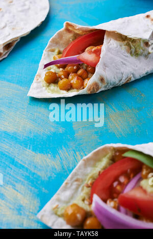 Couches au vegan avec pita les pois chiches et la purée d'avocat sur fond bleu Banque D'Images