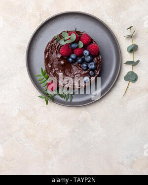 L'espace libre avec du gâteau au chocolat avec des framboises et bleuets sur fond clair. L'espace de copie de texte, de la vue de dessus, flay lay Banque D'Images