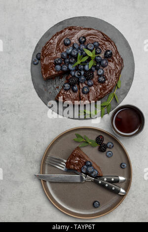 Morceau de gâteau au chocolat avec gâteau sur fond gris, avec tasse de thé avec du thé, avec vaisselle. Haut de la vue, télévision lay, concept de gâteau savoureux Banque D'Images