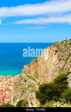 Vue imprenable sur la mer Tyrrhénienne bleu prises d'en haut avec des roches et ville côtière Cefalu en italien en Sicile. Capturé sur un vertical photo Banque D'Images