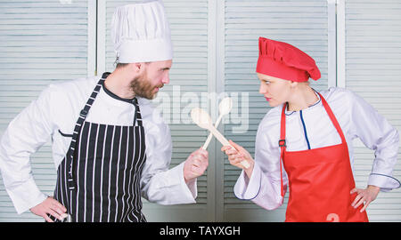 Bataille de deux chefs culinaires. Couple en compétition en arts culinaires Cuisine règles. Bataille culinaire concept. Femme et homme barbu show culinaire concurrents. Qui mieux cuisiner. Cuisine ultime défi. Banque D'Images