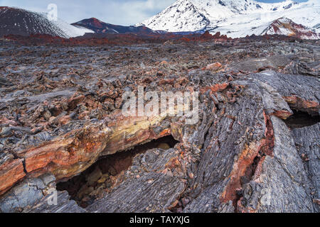 Formation bizarre sur les champ de lave. Montagne de neige dans l'arrière-plan. Le complexe volcanique de la péninsule du Kamtchatka dans l'extrême est de la Russie. Banque D'Images