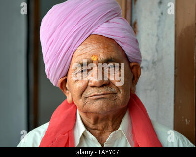 Vieil Indien avec un homme du Rajasthan Rajasthani rose turban (pagari) pose pour la caméra. Banque D'Images