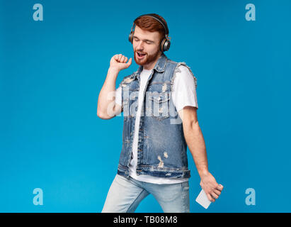 Redhaired homme profiter de la musique et de la danse sur le contexte Banque D'Images