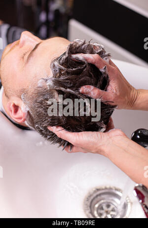 La tête de lavage principal du client dans le salon de coiffure, coiffure, coiffure pour un jeune homme. Banque D'Images