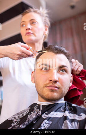 Coupes de cheveux de l'homme principal dans le salon. Ciseaux, Roschetsk close-up. Coiffure Concept, coupe de cheveux, la beauté. Banque D'Images