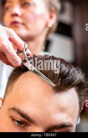 Coupes de cheveux de l'homme principal dans le salon. Ciseaux, Roschetsk close-up. Coiffure Concept, coupe de cheveux, la beauté. Banque D'Images