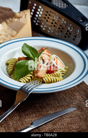 Saumon au four avec des fusillis et épinards. Le concept de la cuisine italienne, classique. Table en conserve magnifiquement avec des pâtes. Banque D'Images