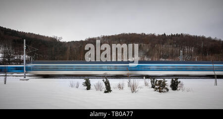 La vitesse des trains à travers une petite ville gare - motion image floue. Le train de voyageurs à grande vitesse en mouvement. Train intercity modernes. Tr de fer Banque D'Images