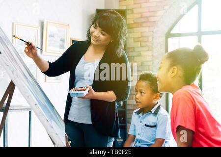 African American boy and girl looking at peinture d'art asiatique au cours de l'enseignant à l'école - Leçon d'éducation pour enfants concept Banque D'Images