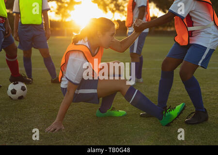 Joueurs de football de faire exercice d'échauffement au terrain de sport Banque D'Images