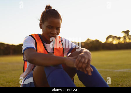 Joueur de football relaxing on grass Banque D'Images