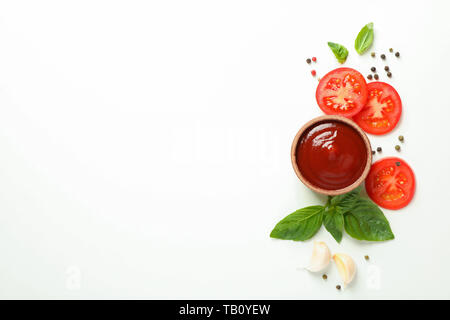 Mise à plat avec des tomates cerise composition tranches, le basilic, le poivre, l'ail et la sauce sur fond blanc, de l'espace pour le texte. Les légumes mûrs Banque D'Images