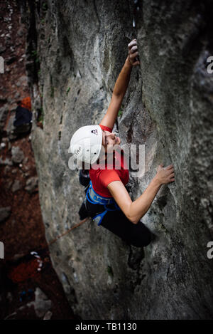 Girl climbing à l'extérieur avec le casque blanc Banque D'Images