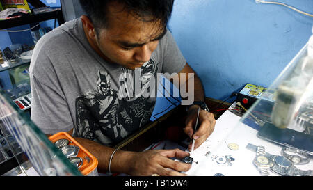 ANTIPOLO CITY, PHILIPPINES - MAY 21, 2019: A watch repair man fixes a wrist watch for a customer. Banque D'Images