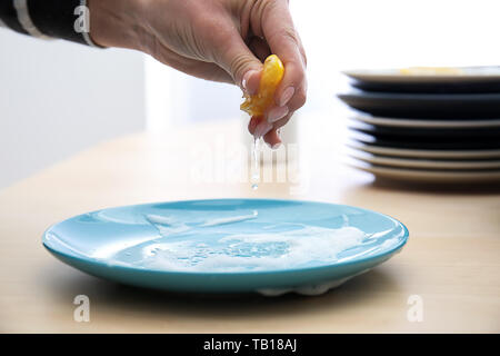 Woman squeezing jus de citron sur la plaque avec de la mousse pour le nettoyer Banque D'Images