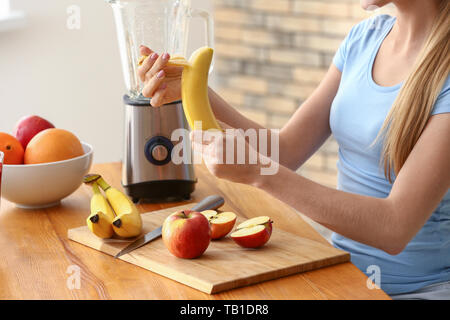 Jeune femme faisant des smoothie à la maison Banque D'Images