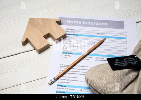 Home Formulaire d'assurance avec de l'argent sac sur le tableau blanc Banque D'Images