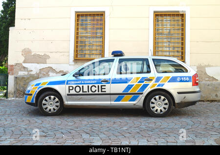 Voiture de police tchèque Skoda Superb stationné près d'un vieux bâtiment sur une chaussée de pierre dans la région de Kutna Hora, République Tchèque Banque D'Images