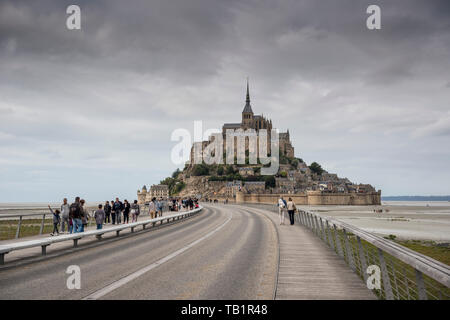 Les touristes et venir à pied le Mont Saint Michel, sur le pont passerelle nouvellement construit, Manche, Normandie, France Banque D'Images