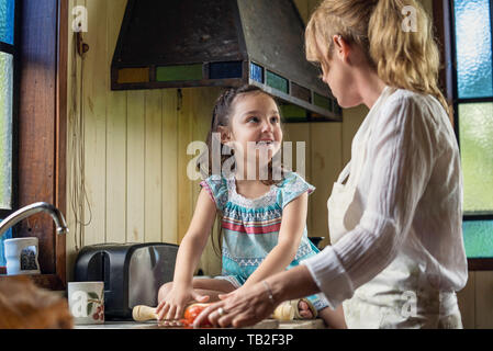 Femme mature parle avec sa petite-fille dans la cuisine Banque D'Images