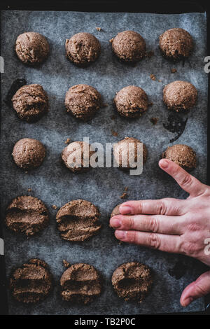 High angle close up de mettre la pâte à biscuit au chocolat sur une plaque de cuisson. Banque D'Images