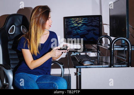 Une jeune femme joue un jeu d'ordinateur Banque D'Images