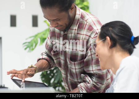 Deux ami avec différents groupes ethniques travaillent ensemble avec ordinateur portable et tablette aborder quelque chose, deux jeune homme travailler et étudier ensemble Banque D'Images