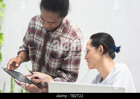 Deux ami avec différents groupes ethniques travaillent ensemble avec ordinateur portable et tablette aborder quelque chose, deux jeune homme travailler et étudier ensemble Banque D'Images